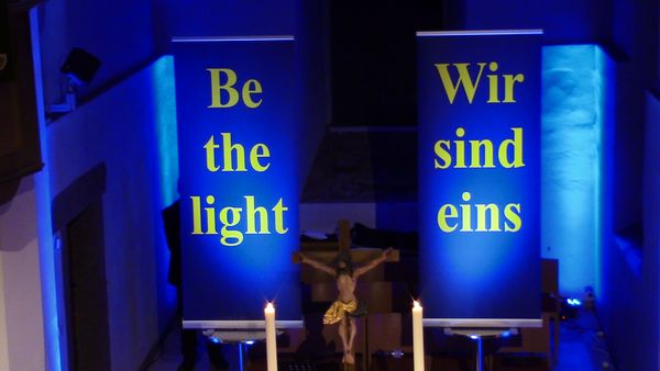 Unser Motto des Abschiedkonzertes suf den Bannern steht "Be the light" und "Wir sind eins"